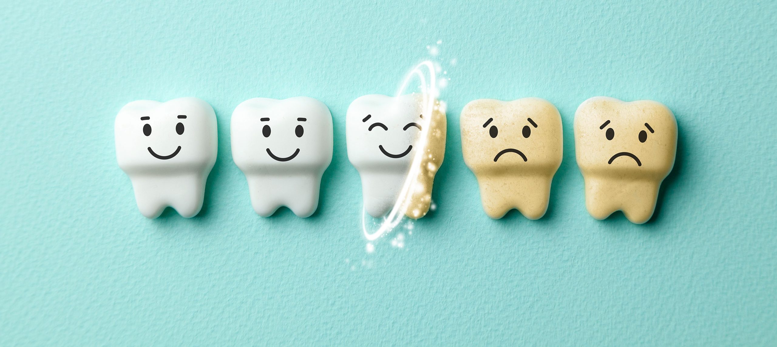Image of 5 teeth. Half are smiling and bright white while the other half are sad and yellowed. They lay against a soft turquoise background. The image signifies the process of teeth whitening.